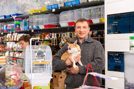 Portrait of adult man with dog in petshop, boy on background