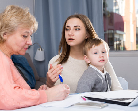 Two women are puzzled of problems with filling utility bills with laptop at home.