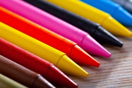 Multicolored wax chalks on wooden background. Concept of artistic education の写真素材
