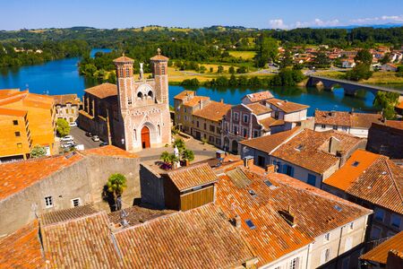 Picturesque summer landscape of small French town of Cazeres on bank of Garonne river overlooking medieval Church of Our Ladyの写真素材