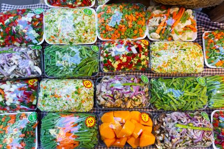 Fresh cut vegetables in sets prepared for cooking on store showcaseの写真素材