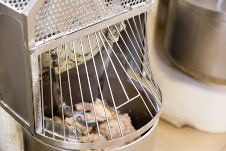 Baker preparing the dough for bread in a dough mixer