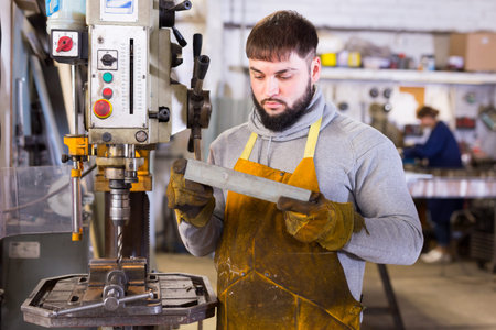 Portrait of professional man working with stainless steel in workshop