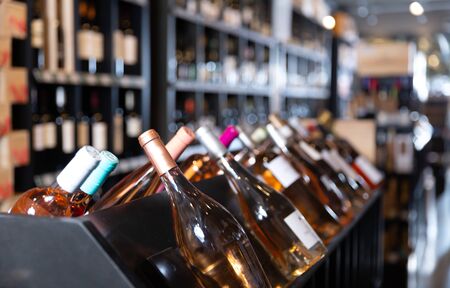 Rack with sparkling wine bottles in modern wine store waiting for customersの写真素材