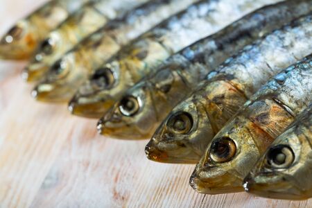 Closeup of salted and pressed sardines on wooden table, with copyspaceの写真素材