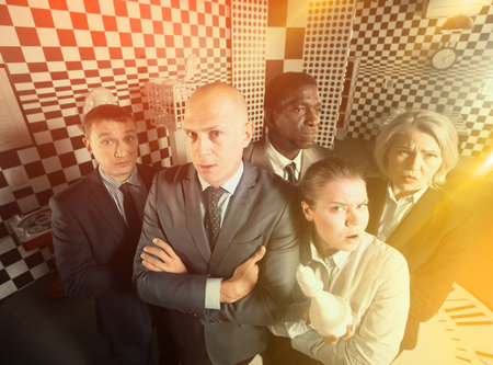 Men and women in pensive poses standing in quest room