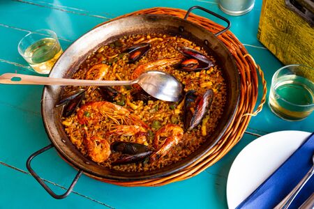 Delicious seafood paella - savory rice dish with shrimps and clams served in traditional spanish paella panの写真素材