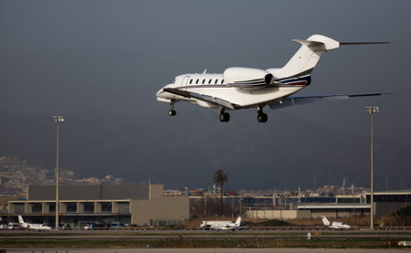 View of modern comfortable private jet on final approaching to runway at Barcelona airportのeditorial素材
