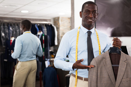Male customer demonstrating his choice of suit in shop