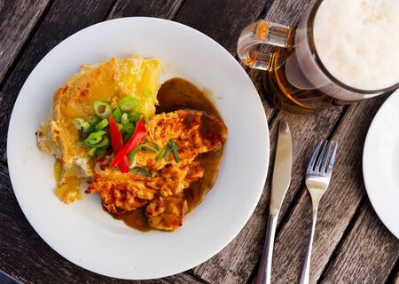 Czech dish - chicken with baked potato served with sauce and greensの写真素材