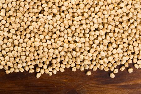 Close up of uncooked chickpea scattered on wooden surfaceの写真素材