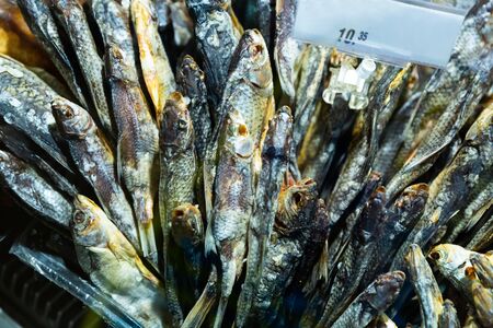 Dried salted freshwater fish on store counter. Traditional Russian snack

の写真素材