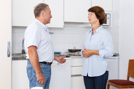 Portrait of unhappy mature couple discussion, quarrel in home interiorの写真素材