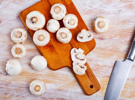 Fresh uncooked champignons on wooden surface. Ingredients for cooking

の写真素材