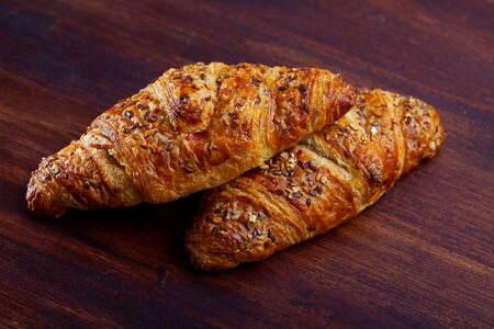 Closeup of delicious sweet croissants at wooden surfaceの写真素材