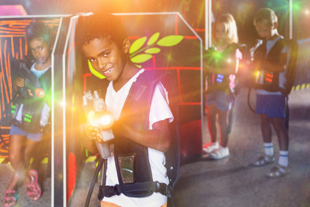Portrait of happy cheerful preteen boy with laser pistol posing in laser tag labyrinthの写真素材