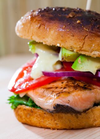 Healthy fish hamburger made with roasted trout fillet and vegetablesの写真素材