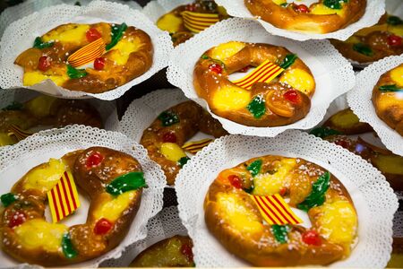 Delicious tortell (Coca de reyes) - ring shaped brioche decorated with sugared fruit and traditionally eaten in Catalonia during celebration of Epiphanyの写真素材