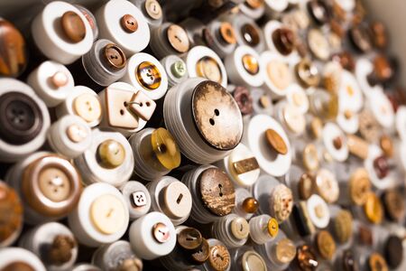 Colorful buttons from metal, wood and plastic on showcase shelves in shopの写真素材