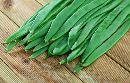 Image of fresh green beans on wooden surface in home kitchen