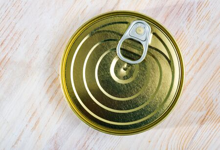 Closeup of unlabelled tin can with easy open lid with ring pull tab on wooden backgroundの写真素材