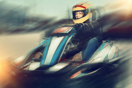 Glad cheerful woman driving sport car for karting  in a circuit lap outdoor in sport club