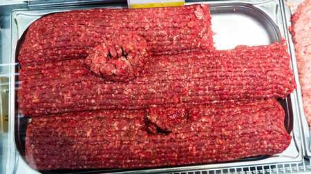 Cooking ingredients, raw minced veal meat in metal tray on showcase ready for saleの写真素材