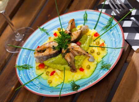 Image of tasty fried trout steaks served  mashed potatoes, guacamole and greens on  plateの写真素材