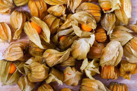 Closeup of yellow ripe physalis fruit (Physalis peruviana) on wooden table. Fruits and vegetables; vegetarian and healthy eating. Ready to eatの写真素材