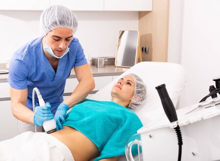 Young woman receiving professional ultrasound rf lifting procedure at beauty clinicの写真素材