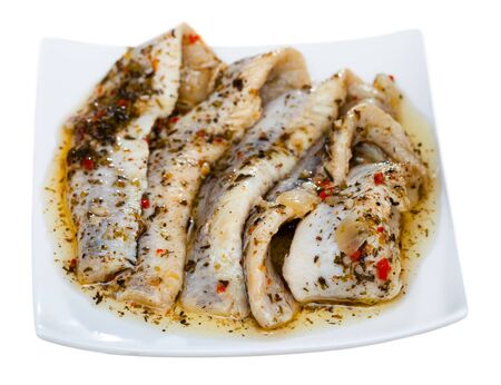 Plate with herring fillet of spicy salting garnished with fresh parsley. Isolated over white backgroundの写真素材