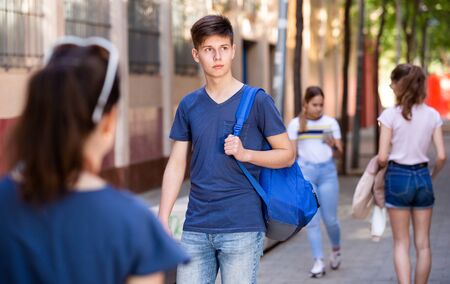 Positive teenager walking in the street, carrying a bag on one shoulderの写真素材