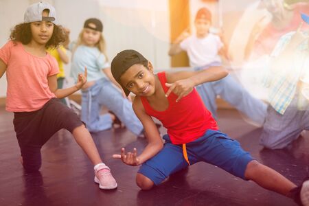 Portrait of african boy and girl training hip hop movements during group class in dance studioの写真素材