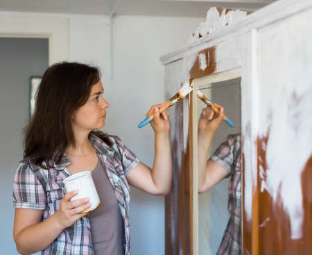 Woman makes repairs in the apartment and paints closetの写真素材