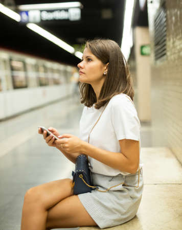 Woman using smartphone in subwayの写真素材