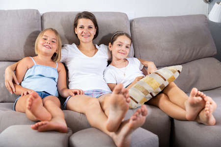 Smiling mom with two children posing in homeの写真素材