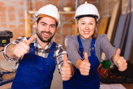 Portrait of two successful workers in uniform inside brick cottageの写真素材