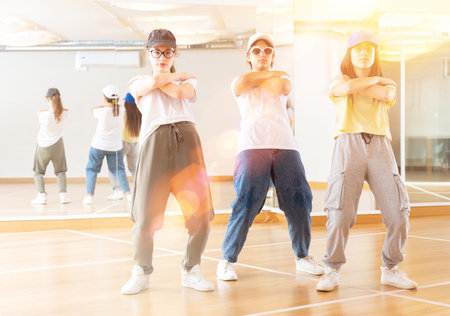 Three slender girls dancing in hip hop dance studio