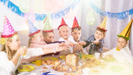 Smiling children enjoying friend festive dinner