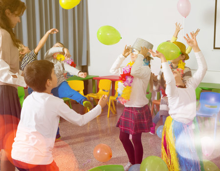 Kids and teacher playing with balloons