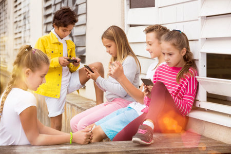 Five kidsare chatting on their smartphone