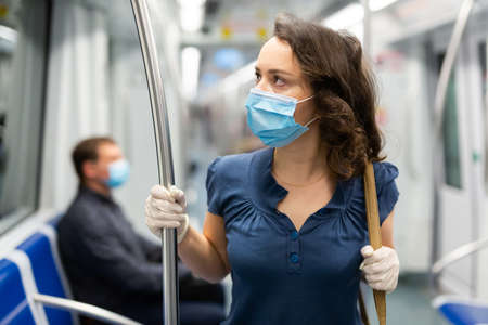 Brunette in medical mask in subway carの写真素材
