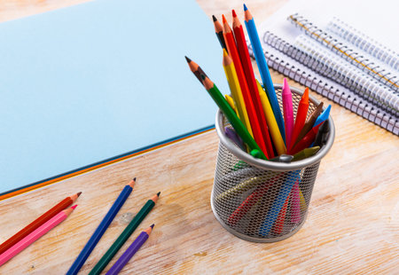 Multicolored pencils and papers on wooden backgroundの写真素材
