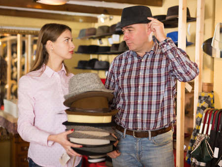 Salesgirl offering hats to manの写真素材