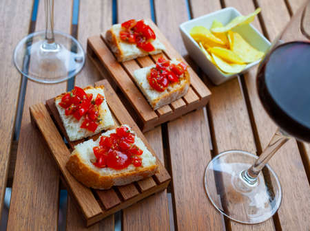 Italian bruschetta with tomato and chips served with wineの写真素材