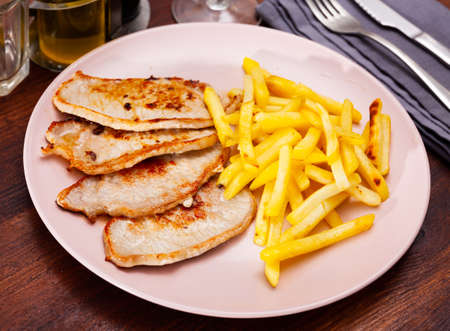 Pork steaks with side dish of crispy friesの写真素材