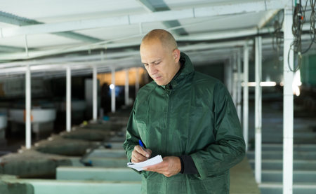 Owner of trout farm checking reservoirs with fry