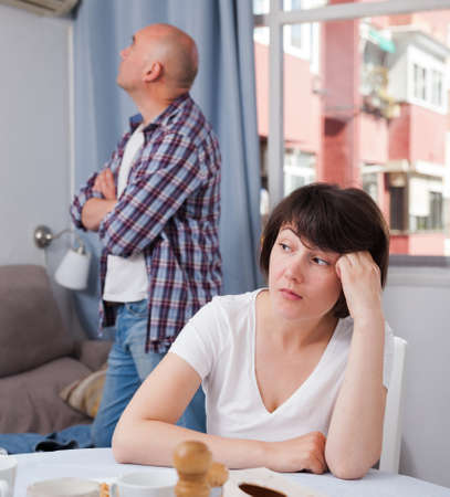 Upset mature woman after quarrel with husband at home interiorの写真素材