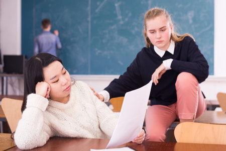 Female classmate calming frustrated Korean teen girlの写真素材