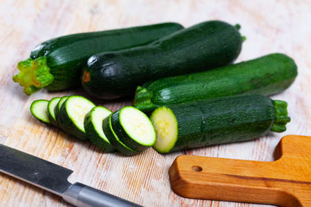 Close-up of fresh green zucchini cut on wooden deskの写真素材
